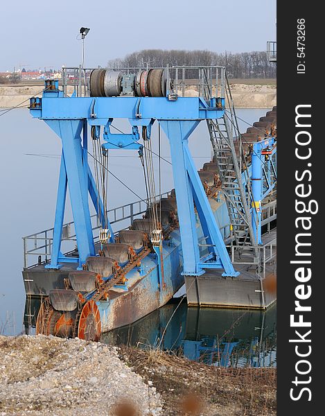 A detail view of a dredger in a gravel pit. A detail view of a dredger in a gravel pit.