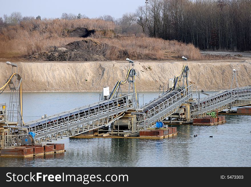 A detail view of a dredger in a gravel pit. A detail view of a dredger in a gravel pit.