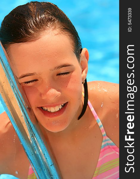 Young girl in the pool, smiling and happy