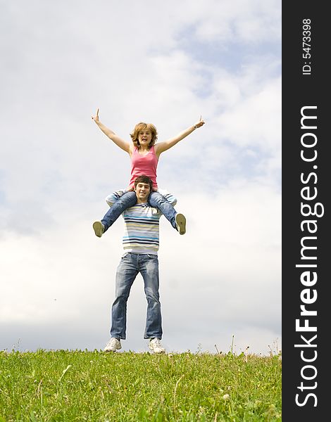 Young Happy Couple Standing On A Green Grass