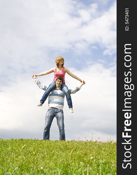 Young happy couple standing on a green grass