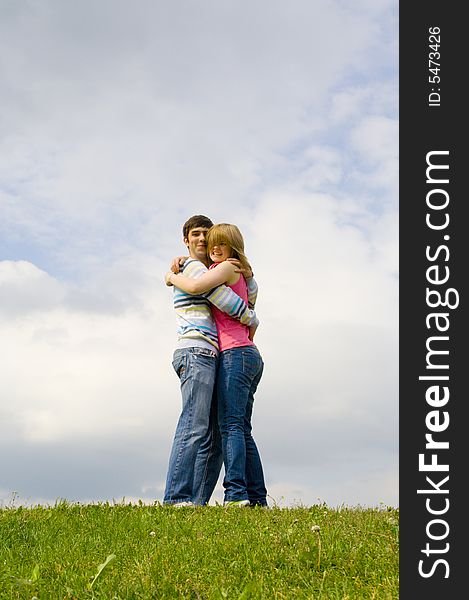 Young happy couple standing on a green grass