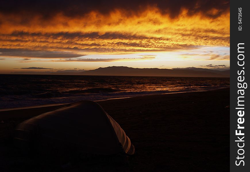 Sunset at Cabo de Gata beach with an upsidedown boat