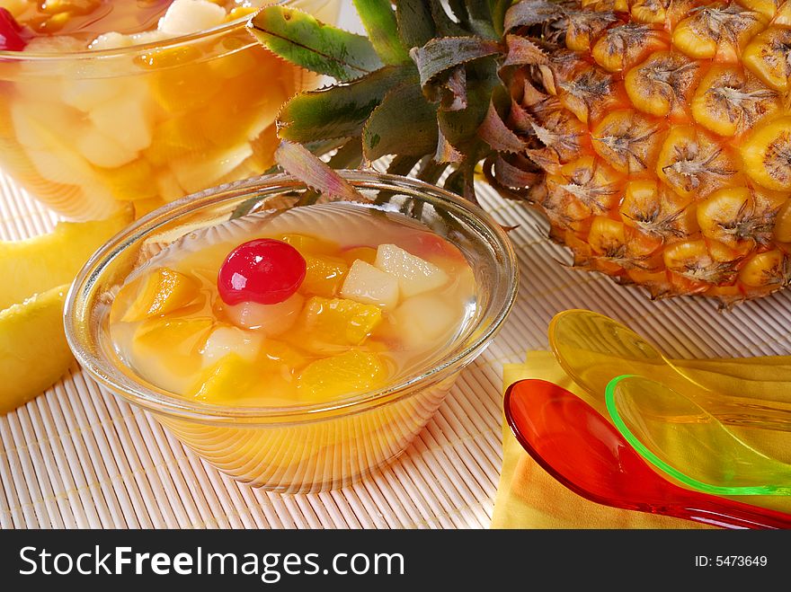 Fruit dessert in a bowl and a pineapple