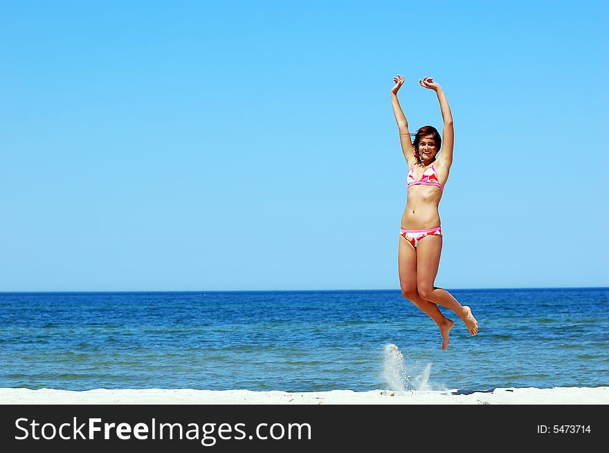 Young attractive woman jump on the beach. Young attractive woman jump on the beach