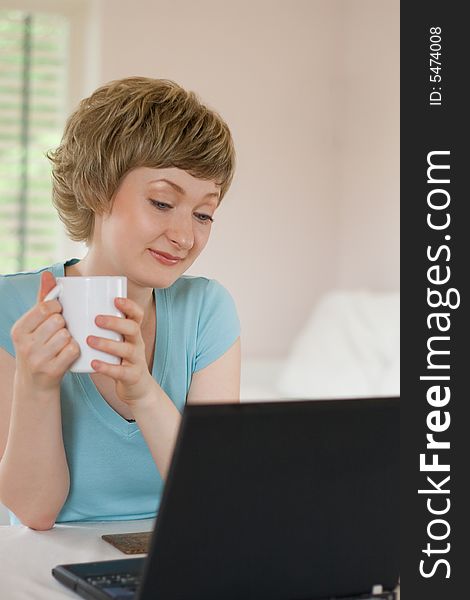 Young woman working on a laptop, indoors, shallow DOF