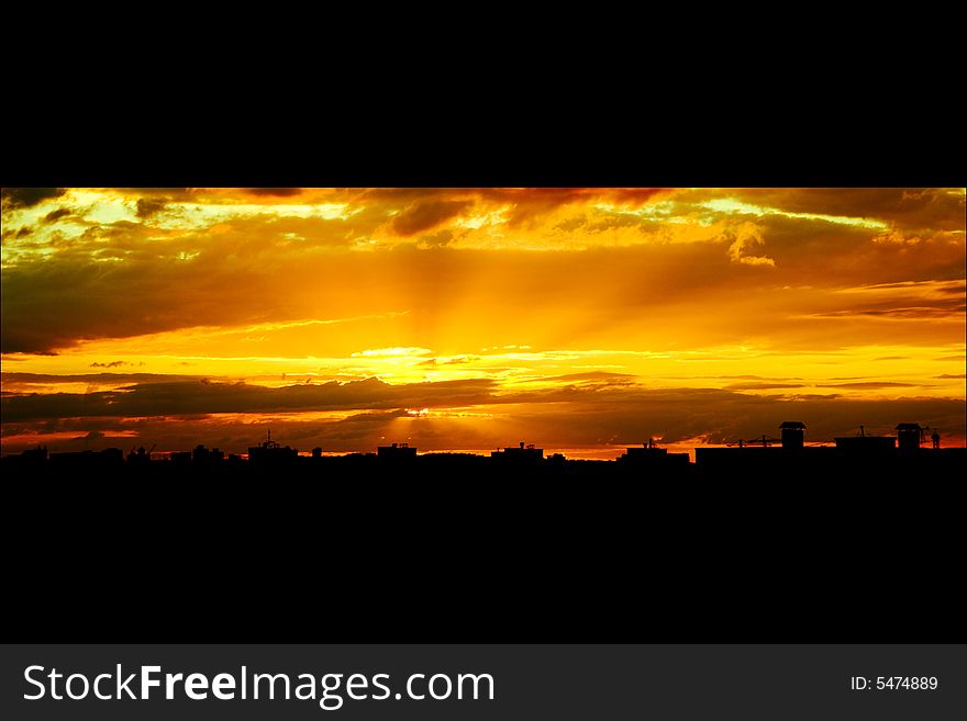 Silhouette of the roofs of houses at sunset.