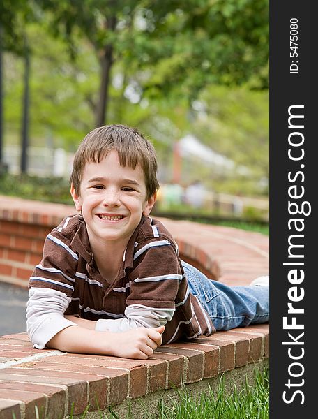 Little Boy Laying Down on Brick Wall. Little Boy Laying Down on Brick Wall