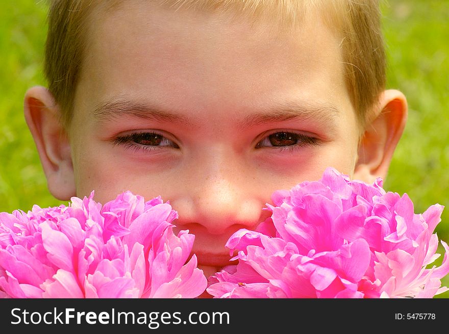 The boy of eight years it smiles smelling the flowers. The boy of eight years it smiles smelling the flowers