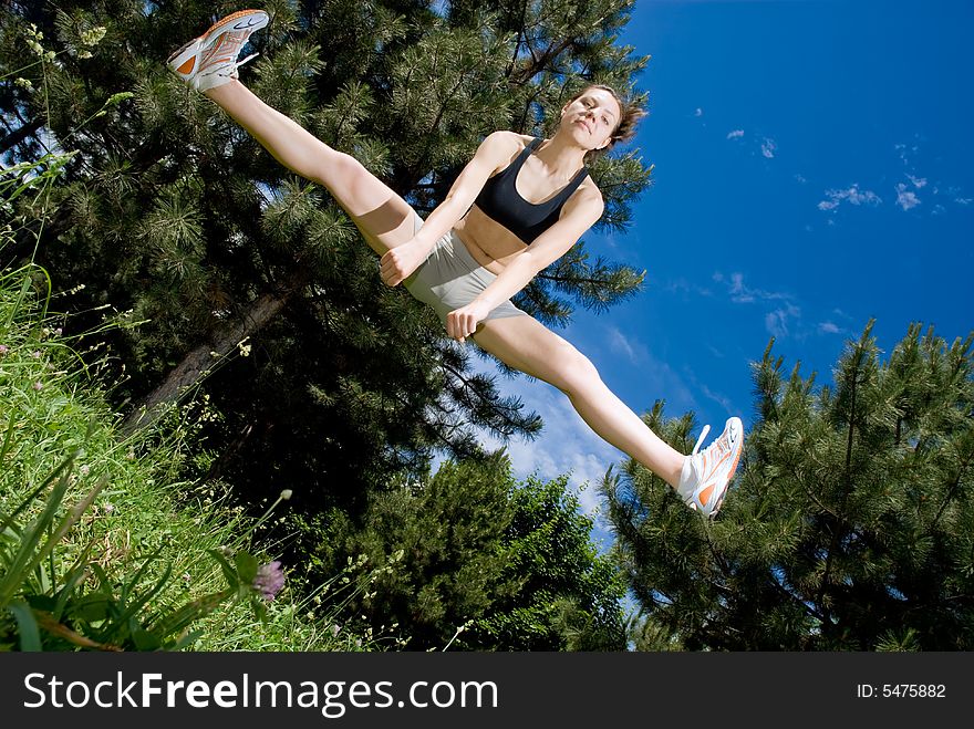 Young happy female jumper, view from below, some motion blur on legs. Young happy female jumper, view from below, some motion blur on legs