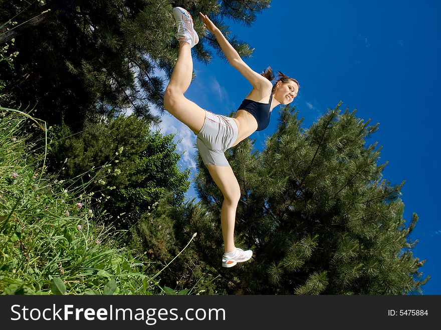 Young happy female jumper, view from below, some motion blur on legs. Young happy female jumper, view from below, some motion blur on legs