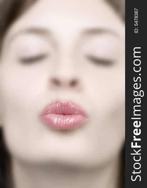 Portrait of a young woman giving a kiss
