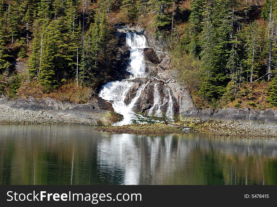Waterfall in the trees of Alaska with nice reflection.