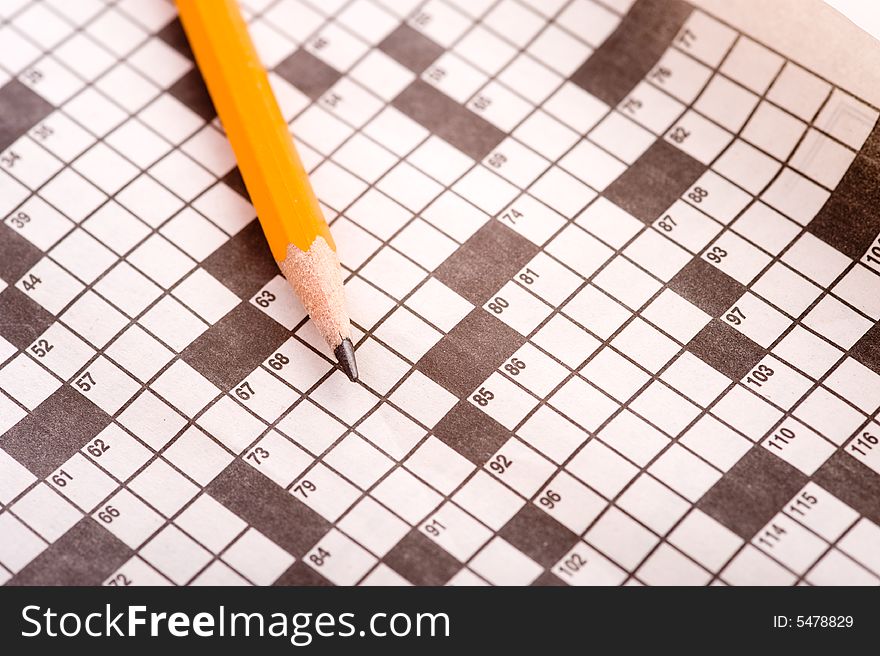 A blank crossword puzzle with a yellow pencil. A blank crossword puzzle with a yellow pencil.