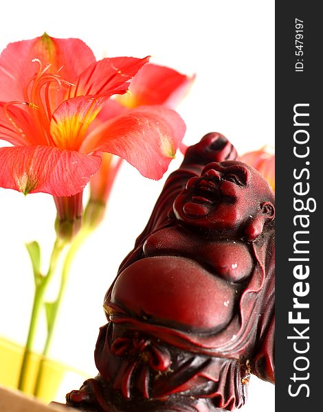 Red Buddha statue with red Peruvian lilies. Red Buddha statue with red Peruvian lilies