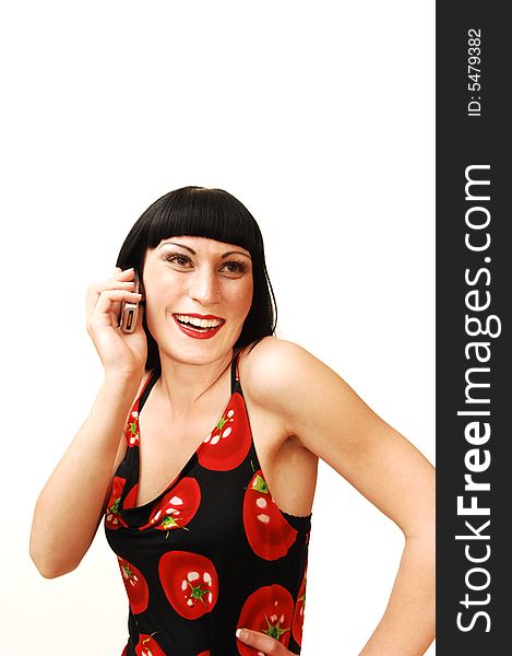 A young pretty woman standing in a studio and having fun talking
on the cell phone for white background in a tomato print dress. A young pretty woman standing in a studio and having fun talking
on the cell phone for white background in a tomato print dress.