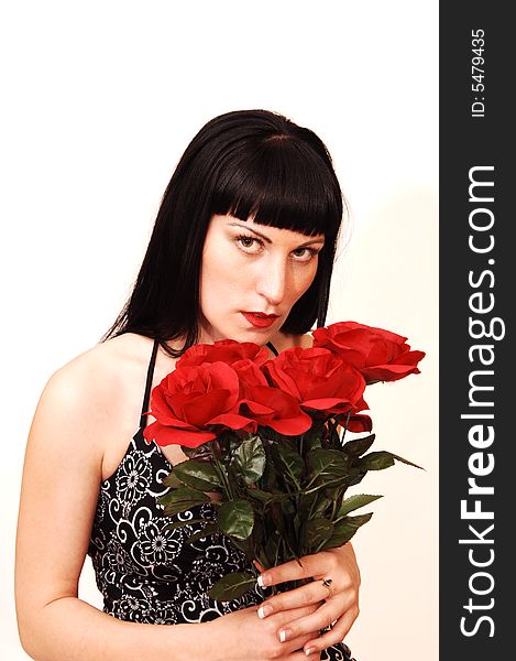 An young pretty girl in a black and white dress and a bunch of red roses
standing in an studio for white background. An young pretty girl in a black and white dress and a bunch of red roses
standing in an studio for white background.