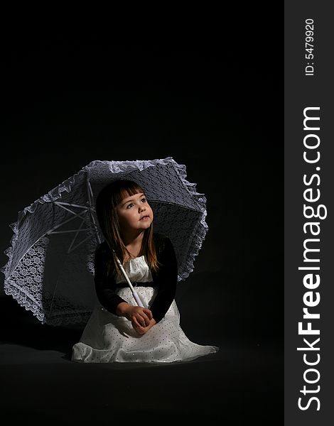 Little girl with chubby cheeks, holding a parasol and looking up. Little girl with chubby cheeks, holding a parasol and looking up