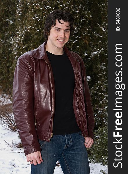 Man posing in front of snow covered trees.