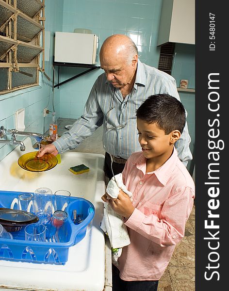 Grandfather and grandson washing dishes - Vertical