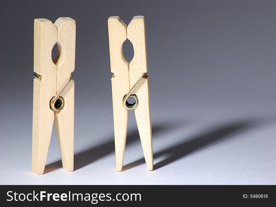 Two clothespins with shadow on gray