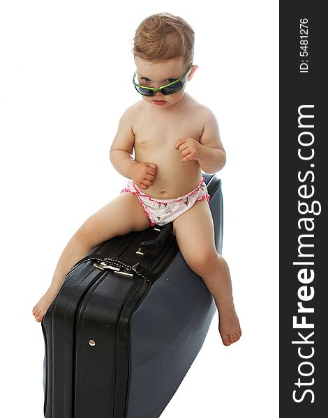 A baby on a valise looking from under goggles