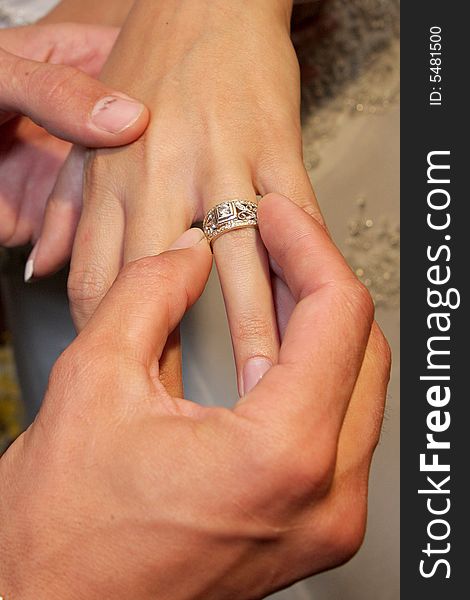 Groom putting on wedding ring. Groom putting on wedding ring