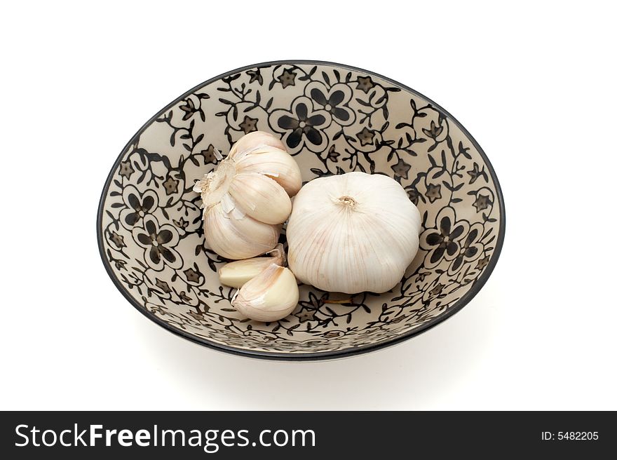 Garlic in a bowl isolated on white with path. Garlic in a bowl isolated on white with path