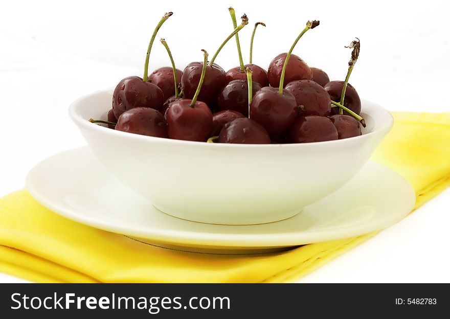 A delicious bowl of ripe cherries on a yellow napkin. A delicious bowl of ripe cherries on a yellow napkin.