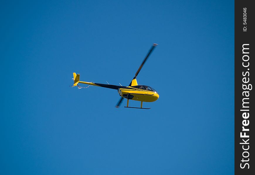 Small yellow privatel Helicopter in blue Sky. Small yellow privatel Helicopter in blue Sky