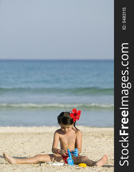 Little child play with sand on beach