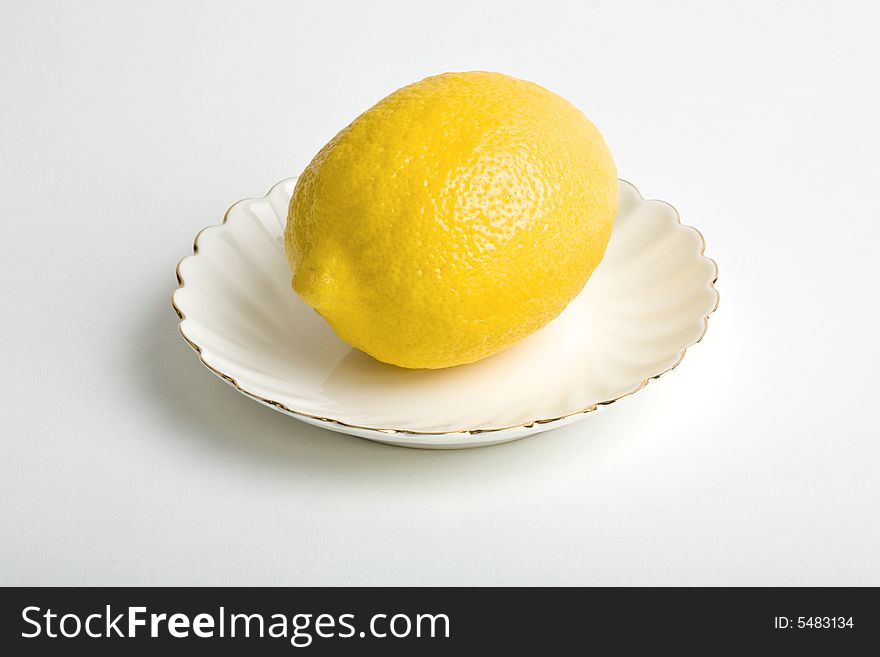 Lemon on a plate. Isolated on the white background.