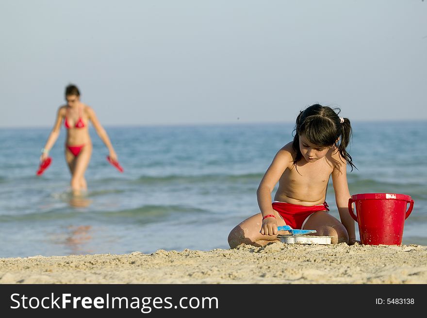 Little child play with sand on beach