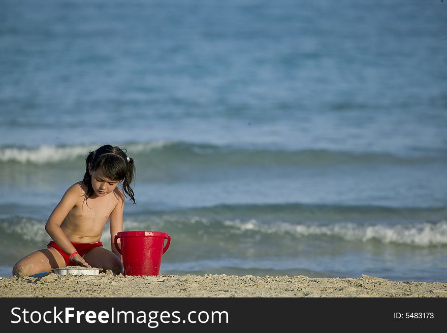 Little child play with sand on beach