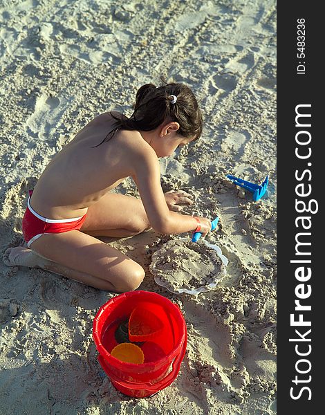 Little child play with sand on beach