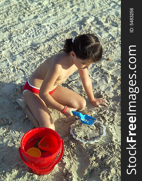 Little child play with sand on beach