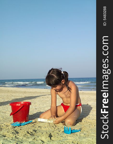 Little child play with sand on beach