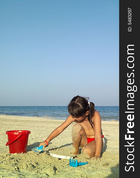 Little child play with sand on beach