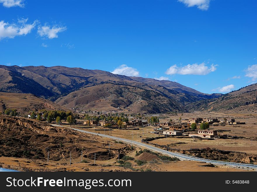 A small village on the way .A mountain landscape with blue sky. A small village on the way .A mountain landscape with blue sky