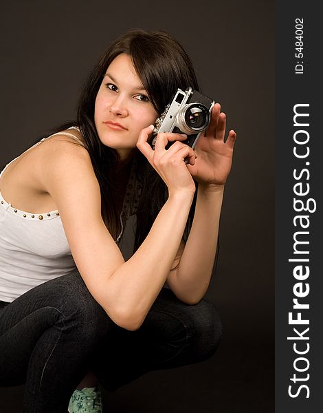 Fashion girl posing with camera isolated on black background. Fashion girl posing with camera isolated on black background