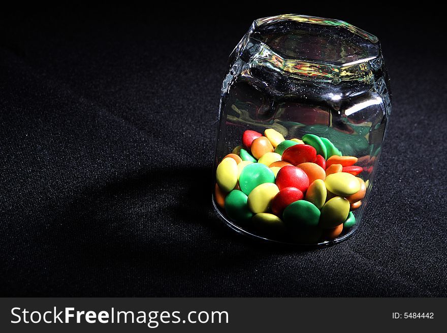 Many colored candies in a glass