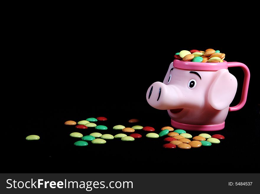 Many colored candies and a piggy bank