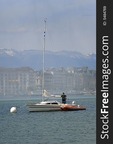 Man on a sailboat preparing to set sail on the lake Leman Geneva Switzerland. Man on a sailboat preparing to set sail on the lake Leman Geneva Switzerland