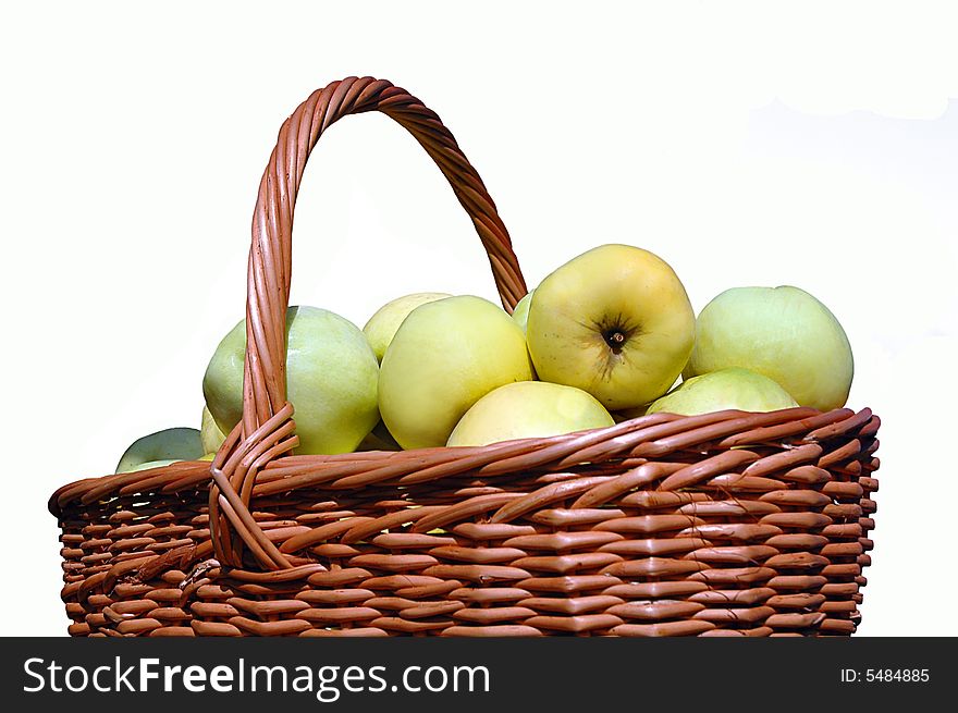 A bunch of green apples in a brown wicker basket on an isolated background. A bunch of green apples in a brown wicker basket on an isolated background.