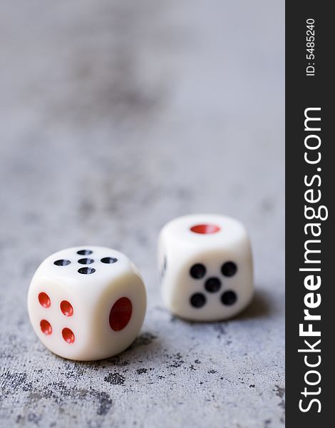 Photo of dice on a concrete floor.