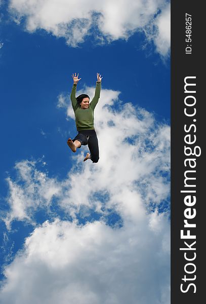 Woman jumping high into the blue sky with puffy clouds. Woman jumping high into the blue sky with puffy clouds.