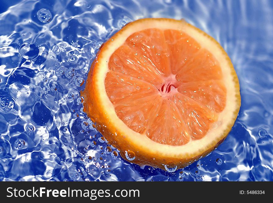 Fresh orange splashing blue water. Fresh orange splashing blue water.