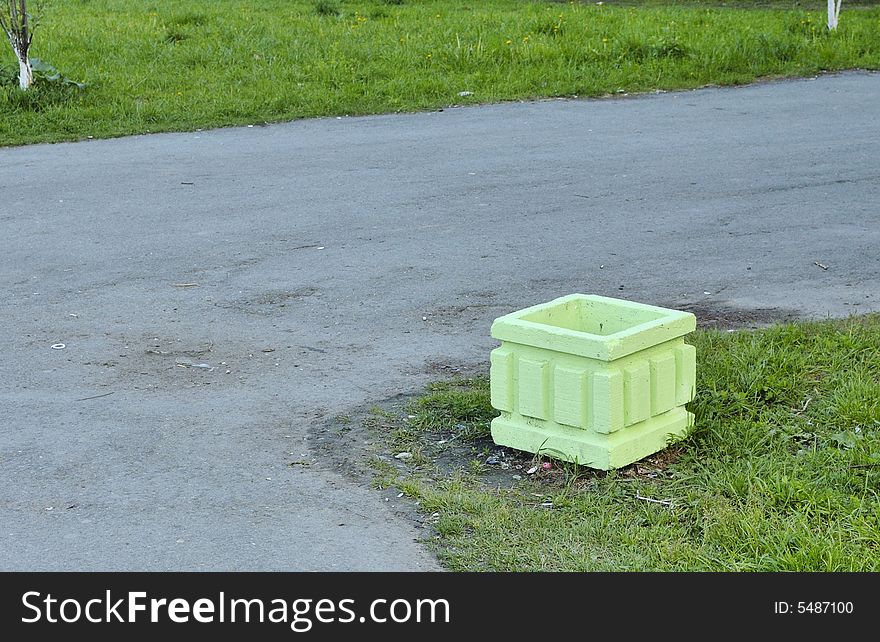 Photo of asphalt pavement and refuse bin colored light-green