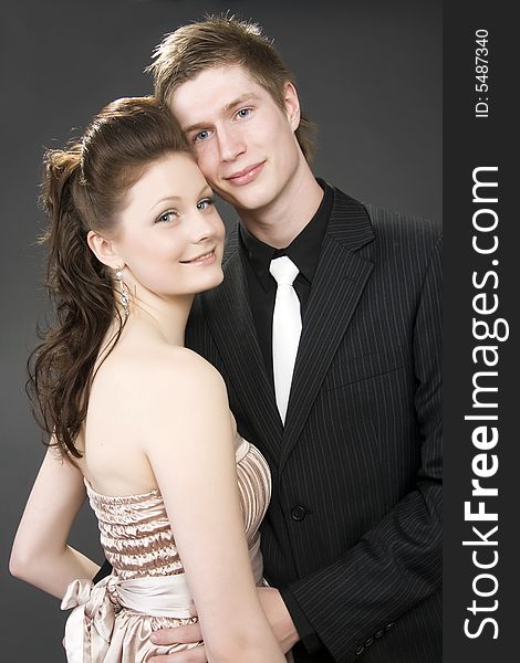 Portrait of a young beautiful couple embracing. (gray background)