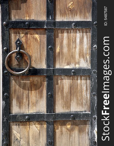 Ancient door with an iron skeleton and metal handle